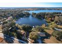 Aerial view of a waterfront community surrounded by mature trees and a large body of water at 9835 Lakeshore Dr, Clermont, FL 34711