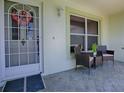 Inviting front porch with tiled flooring, seating, and decorative wreath on door at 1320 Arredondo Dr, The Villages, FL 32162