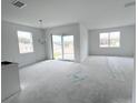 Bright living room with abundant natural light, sliding glass doors to outdoor space, and modern chandelier at 2827 Supermarine Rd, Tavares, FL 32778