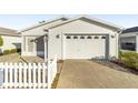 Front view of a white house with a garage and small yard at 2907 Barboza Dr, The Villages, FL 32162