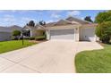 Single-story house with a two-car garage and well-maintained landscaping at 546 Foxfield Path, The Villages, FL 32162