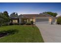 Lovely single-story home with a three-car garage and landscaped yard at dusk at 546 Foxfield Path, The Villages, FL 32162
