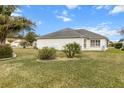 Landscaped backyard with lush grass and tropical plants at 603 San Pedro Dr, Lady Lake, FL 32159