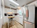 Bright kitchen with stainless steel appliances and wood-look flooring at 1559 Nassau Cir, Tavares, FL 32778