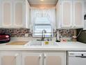 White cabinets and double sink in this updated kitchen at 1559 Nassau Cir, Tavares, FL 32778