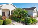 Landscaped front yard with palm tree and walkway at 27103 Camerons Run, Leesburg, FL 34748