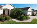 Landscaped front yard with palm tree and walkway at 27103 Camerons Run, Leesburg, FL 34748