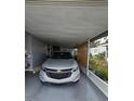 Carport with a silver car parked inside and outdoor plants nearby at 30 Riverview Dr, Fruitland Park, FL 34731