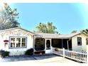 Charming cottage with mature trees, picket fence, bistro set, and decorative mural at 422 W 11Th Ave, Mount Dora, FL 32757