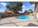 The backyard showcases an inviting private pool with a concrete deck, surrounded by a wooden fence at 5640 Se 21St Ln, Ocala, FL 34480