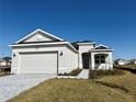 One-story home with gray siding, two-car garage, and a landscaped front yard at 8592 Hempstead Way, Mount Dora, FL 32757