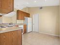 Simple kitchen with wood cabinets, white appliances, and tile flooring at 880 Vindale Rd, Tavares, FL 32778