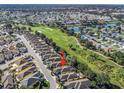 Aerial view of home on the golf course with lush green landscaping, lakes, and community at 3213 Archer Ave, The Villages, FL 32162