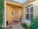 Inviting front entrance with a tiled porch, potted plants, and beautiful, arched window at 3213 Archer Ave, The Villages, FL 32162