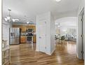 Open-concept kitchen area with stainless steel appliances, hardwood floors, and bright lighting at 3213 Archer Ave, The Villages, FL 32162