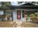 Red front door, stone walkway, and mature landscaping at 505 W Catawba St, Fruitland Park, FL 34731