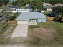 Light teal house with gray roof, attached garage, and fenced yard at 1761 12Th St, Orange City, FL 32763