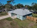 Single story teal home with gray roof, landscaped yard, and wooden fence at 1761 12Th St, Orange City, FL 32763