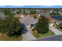 Aerial view of a single-story home showcasing mature trees, a well-manicured lawn, and neighborhood setting at 1828 Feliciana Ter, The Villages, FL 32162