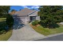Charming single-story home featuring a screened front entry, attached garage, and well-manicured lawn at 1828 Feliciana Ter, The Villages, FL 32162