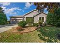 Charming single-story home featuring a well-manicured lawn and an attached two-car garage at 1828 Feliciana Ter, The Villages, FL 32162