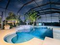 Relaxing pool and spa area with a fountain at night at 1877 Quailey Ct, The Villages, FL 32163