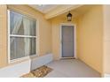 Inviting front porch with gray door, stylish light fixture, and large window at 2169 Smoaks St, The Villages, FL 32162