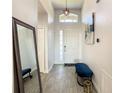 Welcoming entryway, featuring a blue bench and a large mirror at 223 Knollwood Dr, Davenport, FL 33837