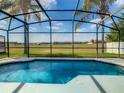 Relaxing screened-in pool with a view of a grassy field at 223 Knollwood Dr, Davenport, FL 33837