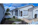 The home features a cozy screened lanai, white picket fence, and a meticulously maintained landscape at 3449 Roanoke St, The Villages, FL 32162