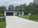 Striking single-story home with black accents, well-manicured lawn, and a spacious driveway at 42157 Tamarac St, Eustis, FL 32736