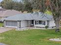 Aerial view of a single-story house with a paver driveway and neatly landscaped lawn at 5004 Saint Andrews Arc, Leesburg, FL 34748