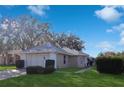 Tan house with gray roof, white trim, and landscaping; daytime photo at 5622 King James Ave, Leesburg, FL 34748