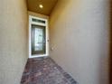 Front entry with brick flooring and modern dark brown door at 765 Walkers Grove Ln, Winter Garden, FL 34787