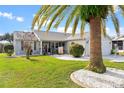 Charming house with palm tree landscaping and welcoming front porch at 1228 Zapata Pl, The Villages, FL 32159