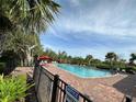 Community pool with patio furniture and umbrellas at 15836 Starlite St, Clermont, FL 34714