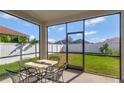 Screened-in porch with a table and chairs, overlooking a grassy backyard at 15836 Starlite St, Clermont, FL 34714
