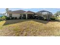 Home's backyard features a screened lanai and spacious grass area at 17112 Se 71St Lewisfield Ter, The Villages, FL 32162