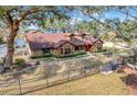 Charming waterfront home featuring mature trees, manicured landscaping, and a cozy front porch at 18033 Rose St, Groveland, FL 34736