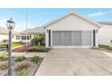 House exterior showcasing a driveway and well-maintained landscaping at 1904 De Hoyos Pl, The Villages, FL 32159