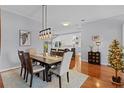 Bright dining room with hardwood floors, a rustic table, and chandelier at 2371 Longbow Trl, The Villages, FL 32162