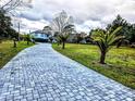 Curving paved driveway with landscaping and a house in the distance at 3180 Sixma Rd, Lake Helen, FL 32744
