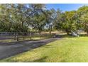 Long driveway leading to a home with a wooden fence and green landscape at 43140 Hossin Around Ln, Altoona, FL 32702