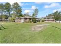 Two-building property view with large grassy front yard and mature trees at 703 & 705 Cleveland Ave, Wildwood, FL 34785