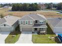 Two-story house with gray siding, gray roof, and a two-car garage at 8511 Triumph Cir, Wildwood, FL 34785