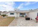 Inviting front patio with brick pavers, seating, and American flag at 10662 Se 174Th Loop, Summerfield, FL 34491