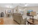Spacious living room with beige leather furniture and a large TV at 10662 Se 174Th Loop, Summerfield, FL 34491