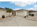 Exterior view of a light yellow house with a garage and landscaping at 1330 Lajolla Cir, The Villages, FL 32159