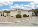 A sunny, one story home showcasing stone landscaping with a neatly trimmed exterior and neutral paint at 1330 Lajolla Cir, The Villages, FL 32159