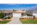 Single-story house with two-car garage and fenced yard at 1387 Zest Ave, The Villages, FL 32163